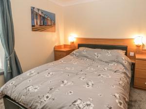 una camera da letto con un letto con un piumone grigio di Ogle Cottage a Bridlington