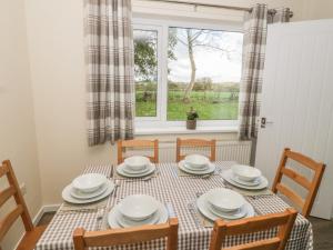 a dining room with a table and chairs and a window at Ty Mon in Menai Bridge