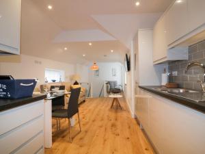 uma cozinha e sala de estar com um balcão e uma mesa em Fishermans Loft em Mevagissey