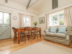 uma sala de estar com uma mesa e um sofá em Oreo's Cottage em St. Agnes