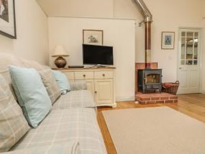uma sala de estar com um sofá e uma lareira em Oreo's Cottage em St. Agnes