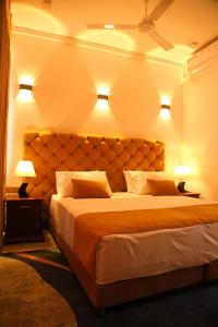 een slaapkamer met een groot bed met 2 lampen bij Crown & Crown Kandy in Kandy