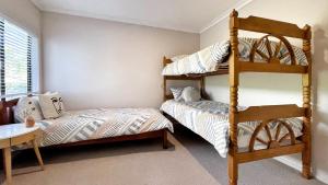 a bedroom with two bunk beds and a table at Habour View - Tauranga Central in Tauranga