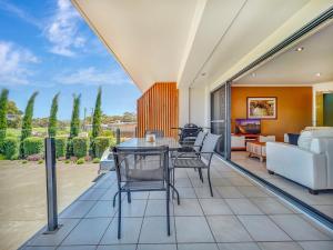 un soggiorno a pianta aperta con tavolo e sedie di Seachange Apartments Merimbula a Merimbula