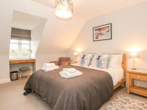 a bedroom with a bed with two towels on it at Swan Cottage in Arundel