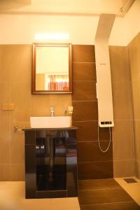 een badkamer met een wastafel en een spiegel aan de muur bij Crown & Crown Kandy in Kandy