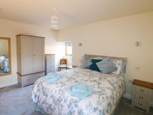 um quarto com uma cama com toalhas azuis em The Stables em Parwich