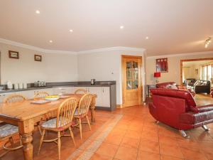 a kitchen and living room with a wooden table and chairs at The Glebe in Invergordon
