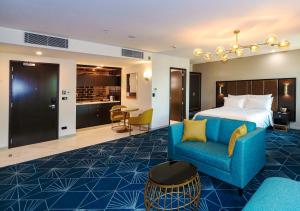 um quarto de hotel com uma cama e um sofá azul em Swiss-Belboutique Napier em Napier