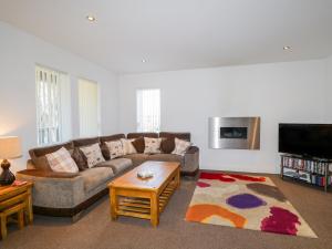 a living room with a couch and a tv at The Beeches in Forres