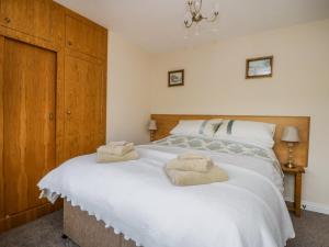 a bedroom with a large white bed with towels on it at Acorn Cottage in Bradford