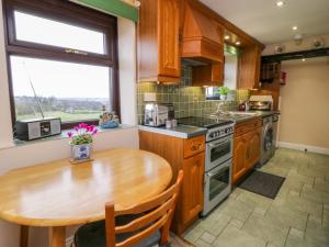 eine Küche mit einem Holztisch, einem Holztisch und einem Holztisch in der Unterkunft Acorn Cottage in Bradford