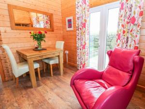 uma sala de estar com um sofá vermelho e uma mesa em Borah Lodge em Penzance