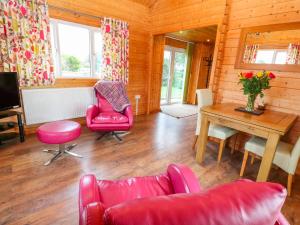 彭贊斯的住宿－Borah Lodge，客厅配有红色家具和桌子
