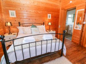 een slaapkamer met een bed in een blokhut bij Borah Lodge in Penzance