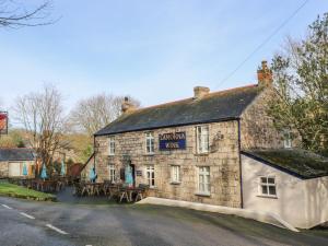 een oud stenen gebouw met tafels ervoor bij Borah Lodge in Penzance
