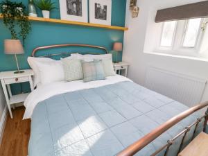a bedroom with a bed with a blue wall at 3 Poole End in Clitheroe