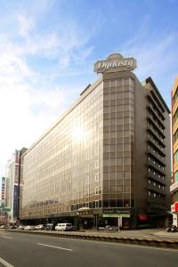 een groot gebouw met een bord erop bij Dynasty Hotel in Tainan