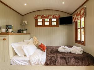 a bedroom with a bed with white sheets and pillows at Little Silver Owl in High Bickington