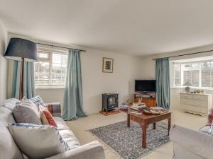 a living room with a couch and a table at Long Barn in Burton Bradstock
