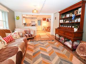 a living room with a couch and a piano at Spring Park Farmhouse in Launceston