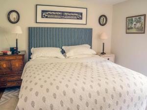 sypialnia z dużym białym łóżkiem z 2 poduszkami w obiekcie All Souls Cottage w mieście Cirencester