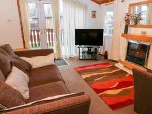 a living room with a couch and a fireplace at The Cedars in Carnforth