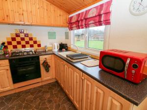 a kitchen with a red microwave on a counter at The Cedars in Carnforth
