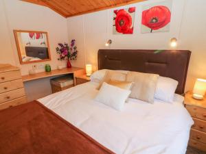 um quarto com uma grande cama branca e uma cabeceira em madeira em The Cedars em Carnforth