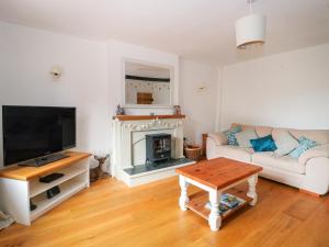 a living room with a couch and a fireplace at Greenham Cottage in Chiselborough