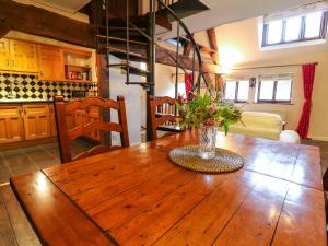 a kitchen with a wooden table with a vase of flowers on it at The Old Cider Press in Broadway