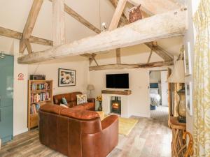 a living room with a leather couch and a fireplace at Megs Cottage in Alveston