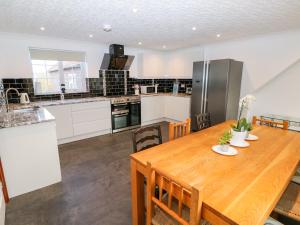 a kitchen with a wooden table and a refrigerator at Balmedie in Market Rasen