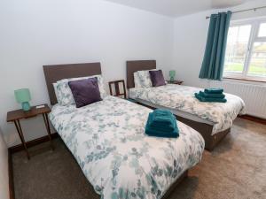 Un dormitorio con dos camas con toallas encima. en Balmedie, en Market Rasen