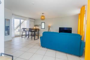 sala de estar con sofá azul y mesa en Cap Homard - spacieux apt - magnifique vue mer -proche plage, en Saint-Gilles-les-Bains