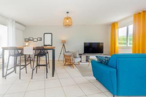 sala de estar con sofá azul y mesa en Cap Homard - spacieux apt - magnifique vue mer -proche plage, en Saint-Gilles-les-Bains