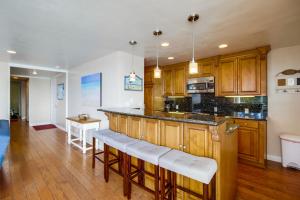 a kitchen with wooden cabinets and a island with bar stools at Devon Retreat Unit D in San Diego