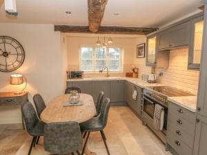 a kitchen with a table and chairs and a sink at Orchard Barn in Stone
