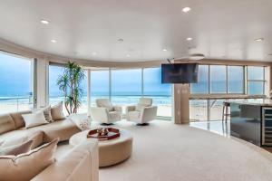 a living room with a white couch and a tv at Ostend Getaway in San Diego
