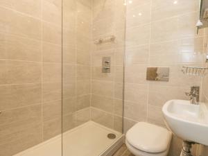 a bathroom with a shower and a toilet and a sink at 2 Riverside Walk in Airton