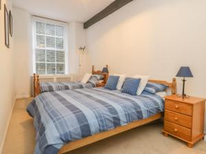 a bedroom with two beds and a night stand at 2 Riverside Walk in Airton