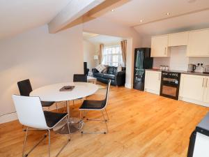 una cucina e un soggiorno con tavolo e sedie di Commonwood Cottage a Wrexham