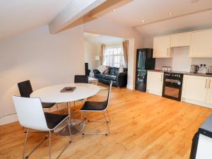 a kitchen and living room with a table and chairs at Commonwood Cottage in Wrexham