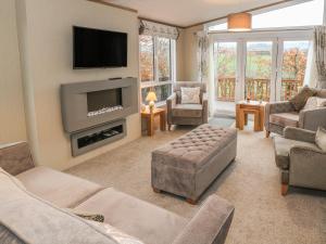 ein Wohnzimmer mit einem Sofa und einem TV in der Unterkunft Avonal Lodge 24 in Perth
