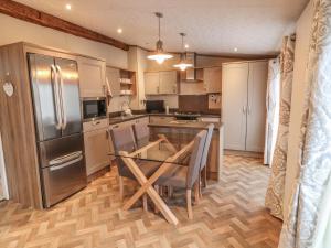 eine Küche mit einem Tisch und einem Kühlschrank aus Edelstahl in der Unterkunft Avonal Lodge 24 in Perth