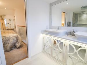 a bathroom with two sinks and a mirror at 8 Crown Lane in Conwy +15 photos