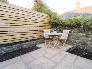 two chairs and a table in front of a fence at 8 Crown Lane in Conwy