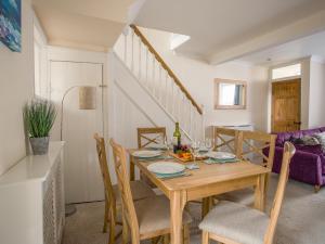 a dining room with a wooden table and chairs at Wey Cottage in Weymouth +9 photos