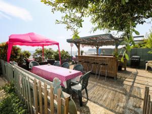 eine Terrasse mit einem Tisch und Stühlen sowie einer Bar in der Unterkunft Crab Cottage in Bembridge