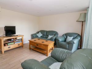a living room with two couches and a tv at The Granary in Halstead